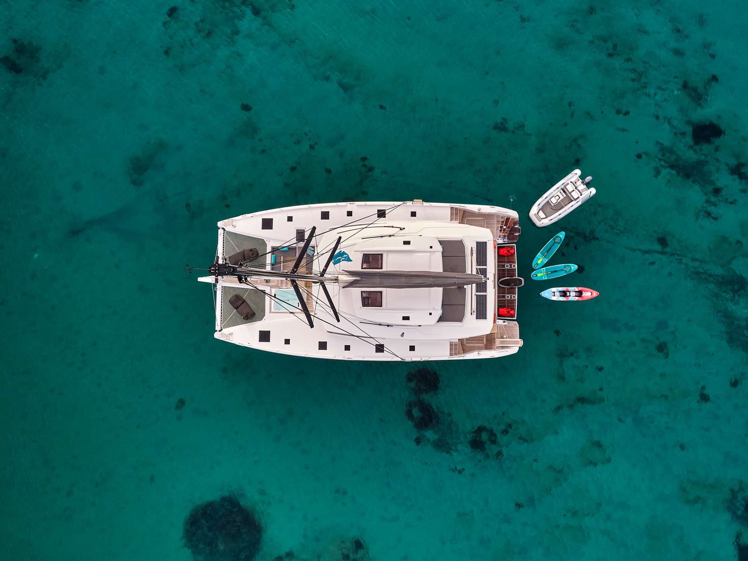 DOLLY - aerial overhead view of the catamaran over turquoise water | Drivas Yachts