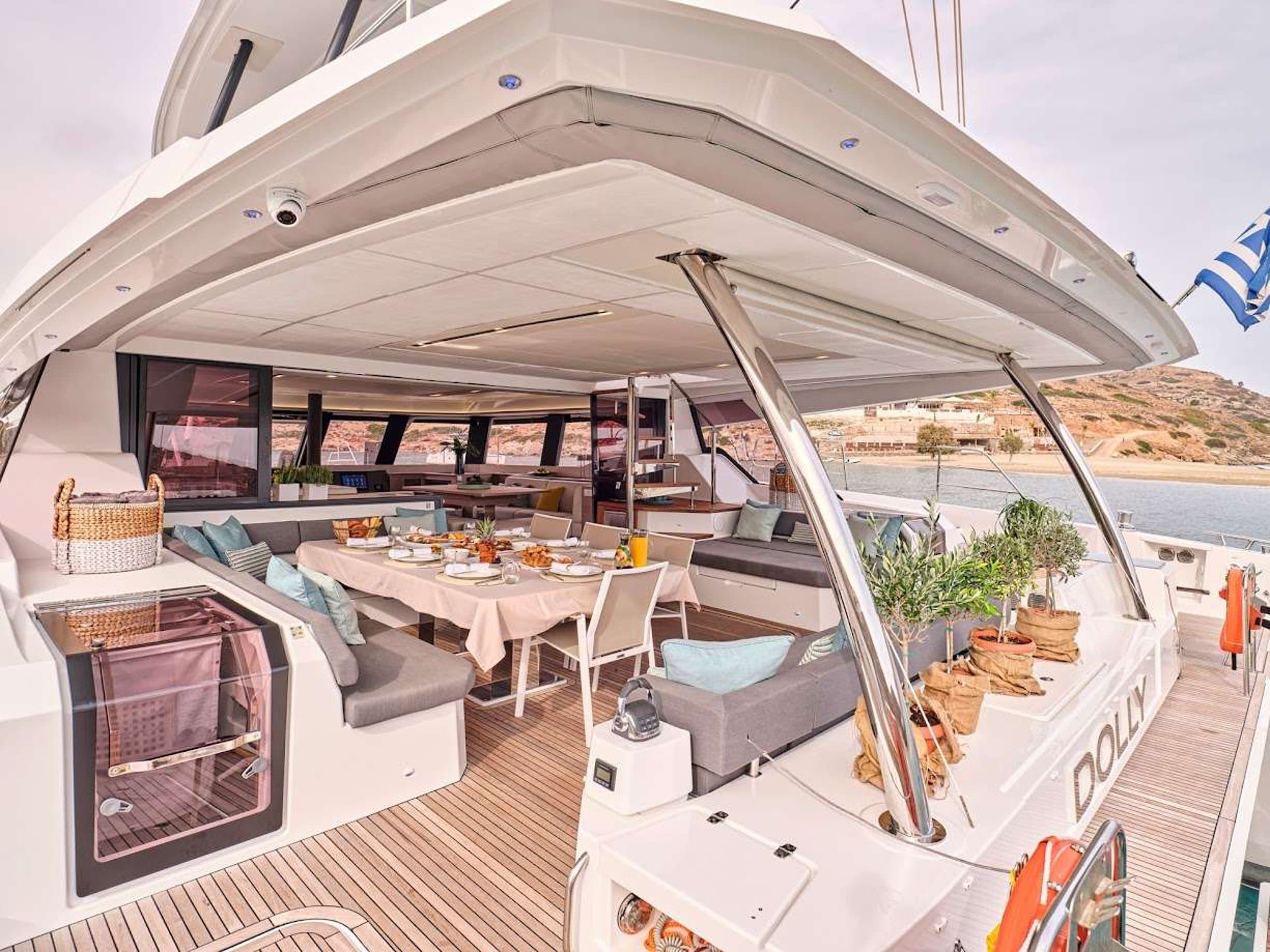 DOLLY - aft deck alfresco dining table set for a meal | Drivas Yachts