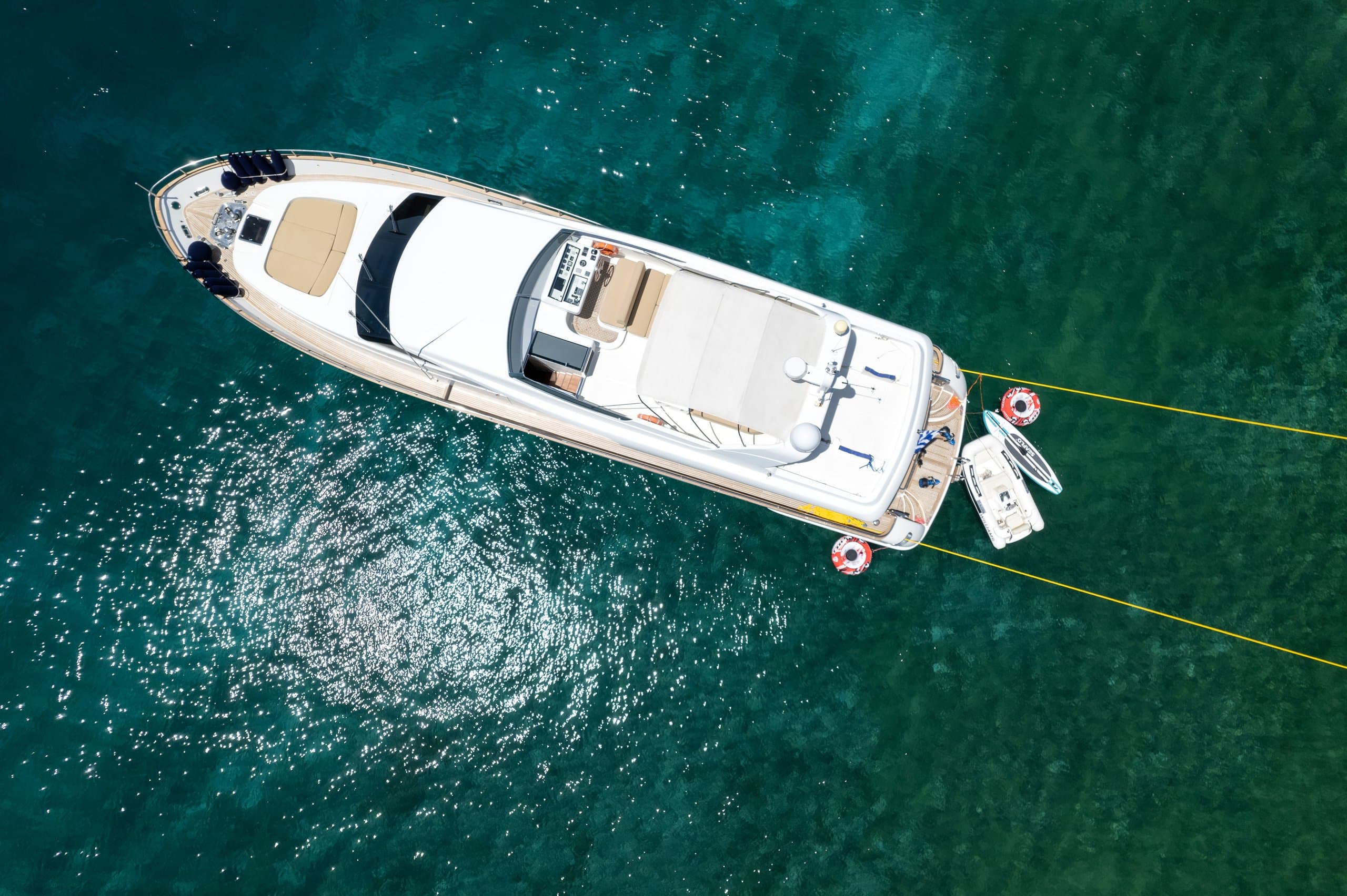 ALEGRIA - overhead aerial view of the yacht moored stern-to with tender over green water | Drivas Yachts
