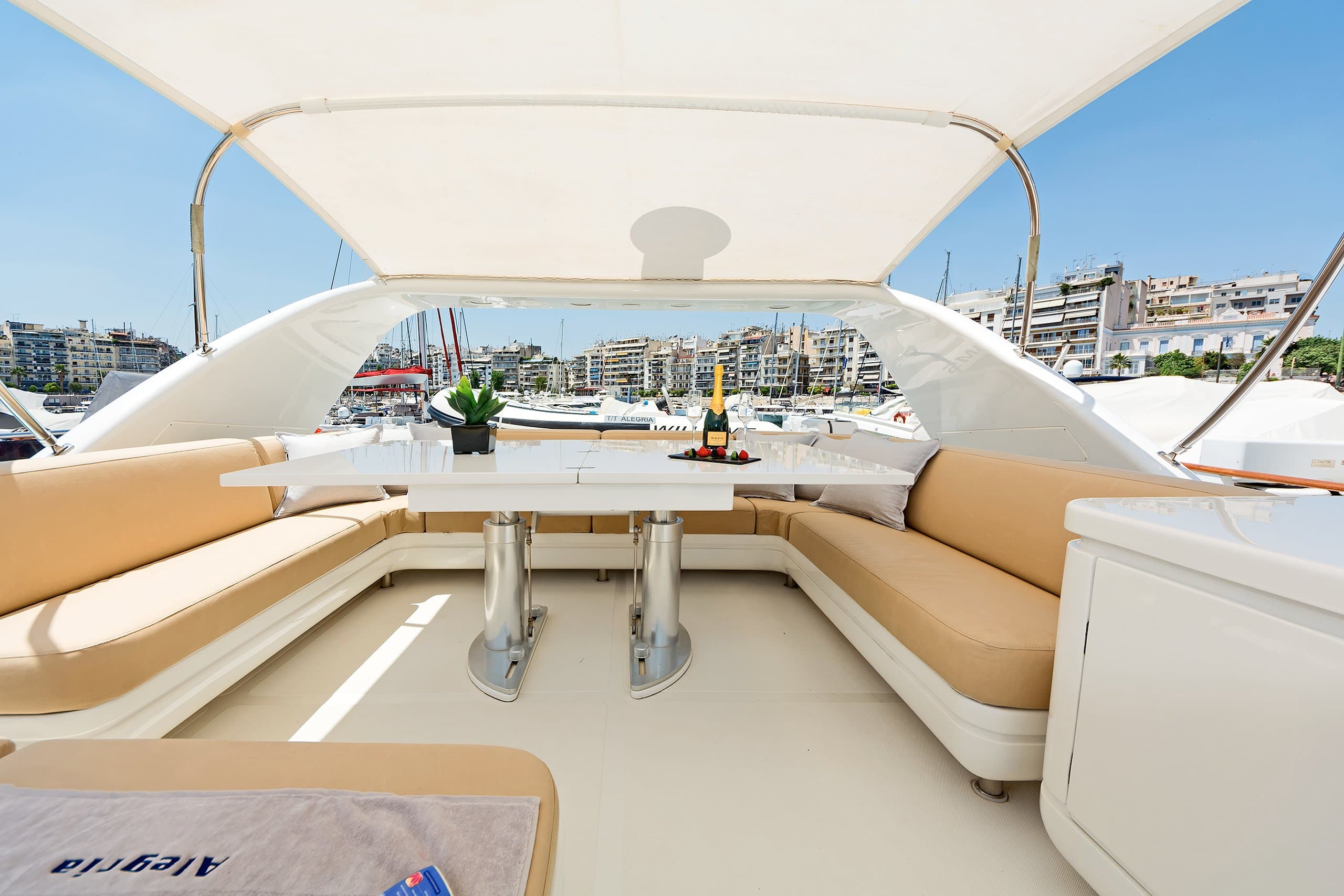 ALEGRIA - flybridge seating area with dining table and champagne, marina view | Drivas Yachts