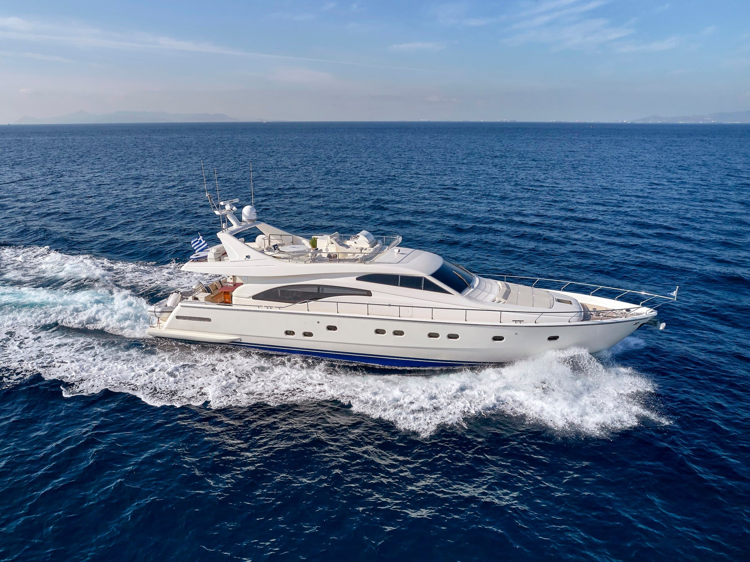 MIREN - full starboard-side profile underway, white hull throwing spray across deep blue sea | Drivas Yachts