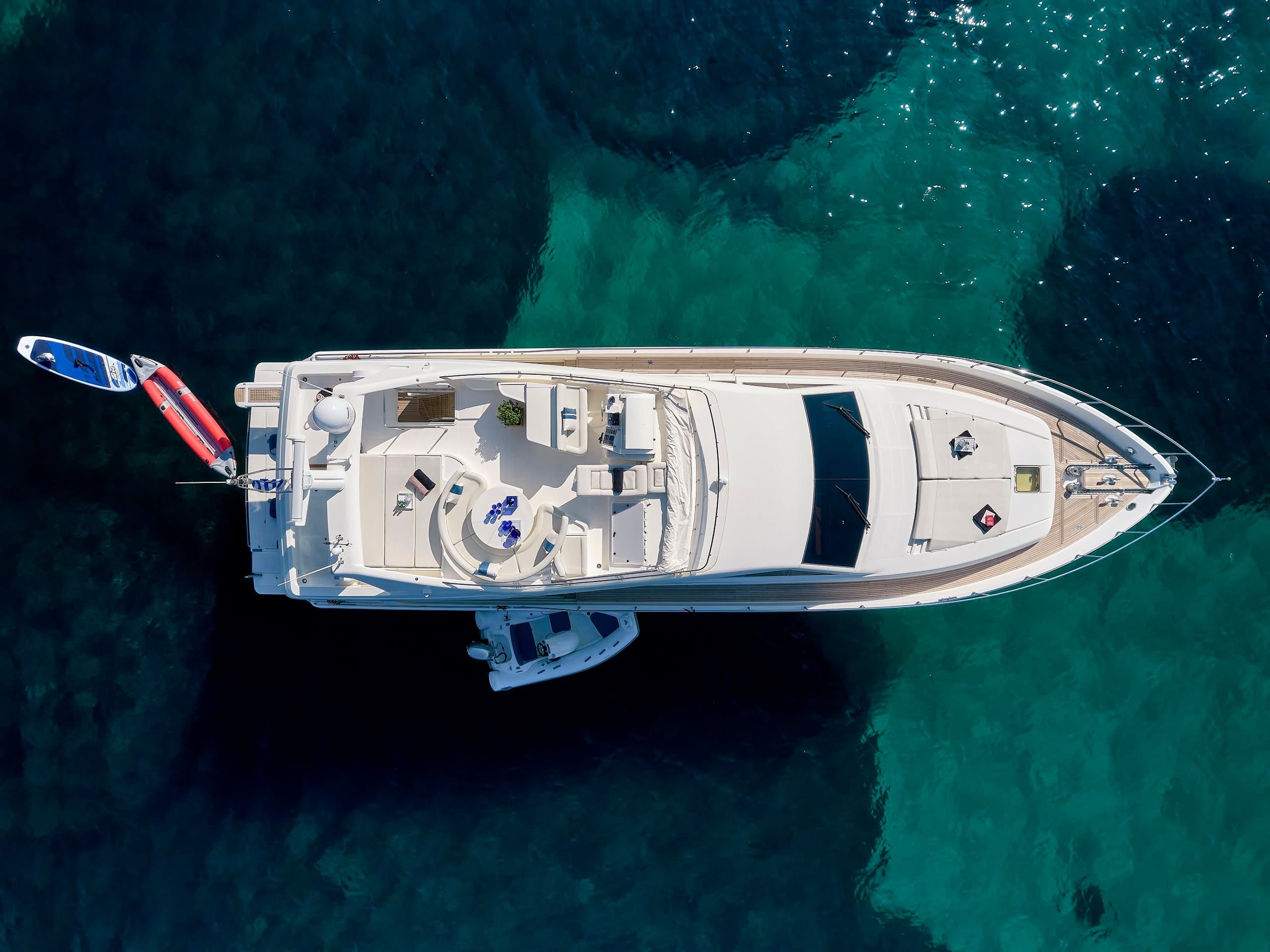 MIREN - overhead aerial view at anchor over turquoise water, foredeck sunpads and tender alongside | Drivas Yachts