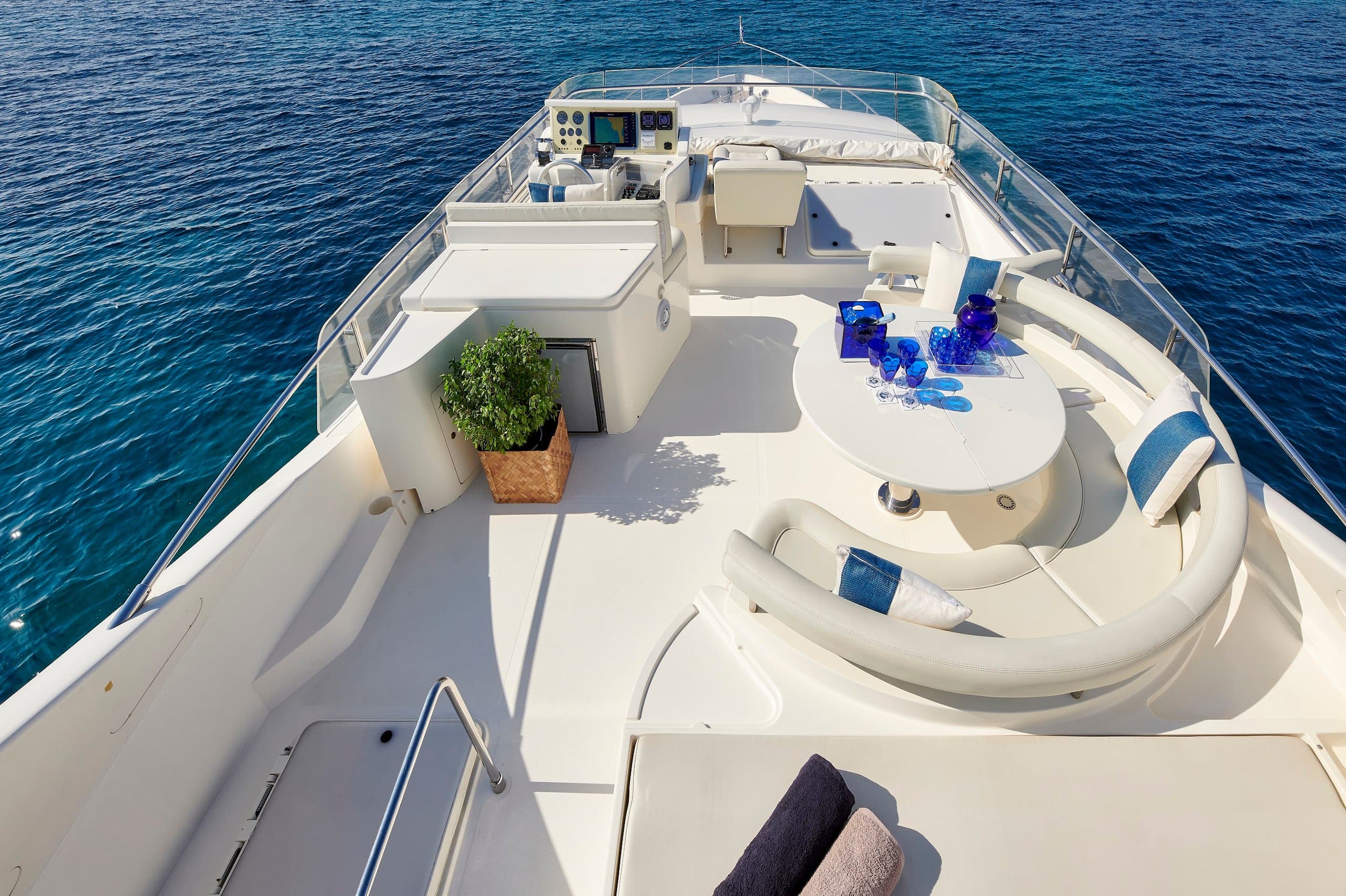 MIREN - flybridge helm station with dining table and curved sun lounger, viewed from above | Drivas Yachts
