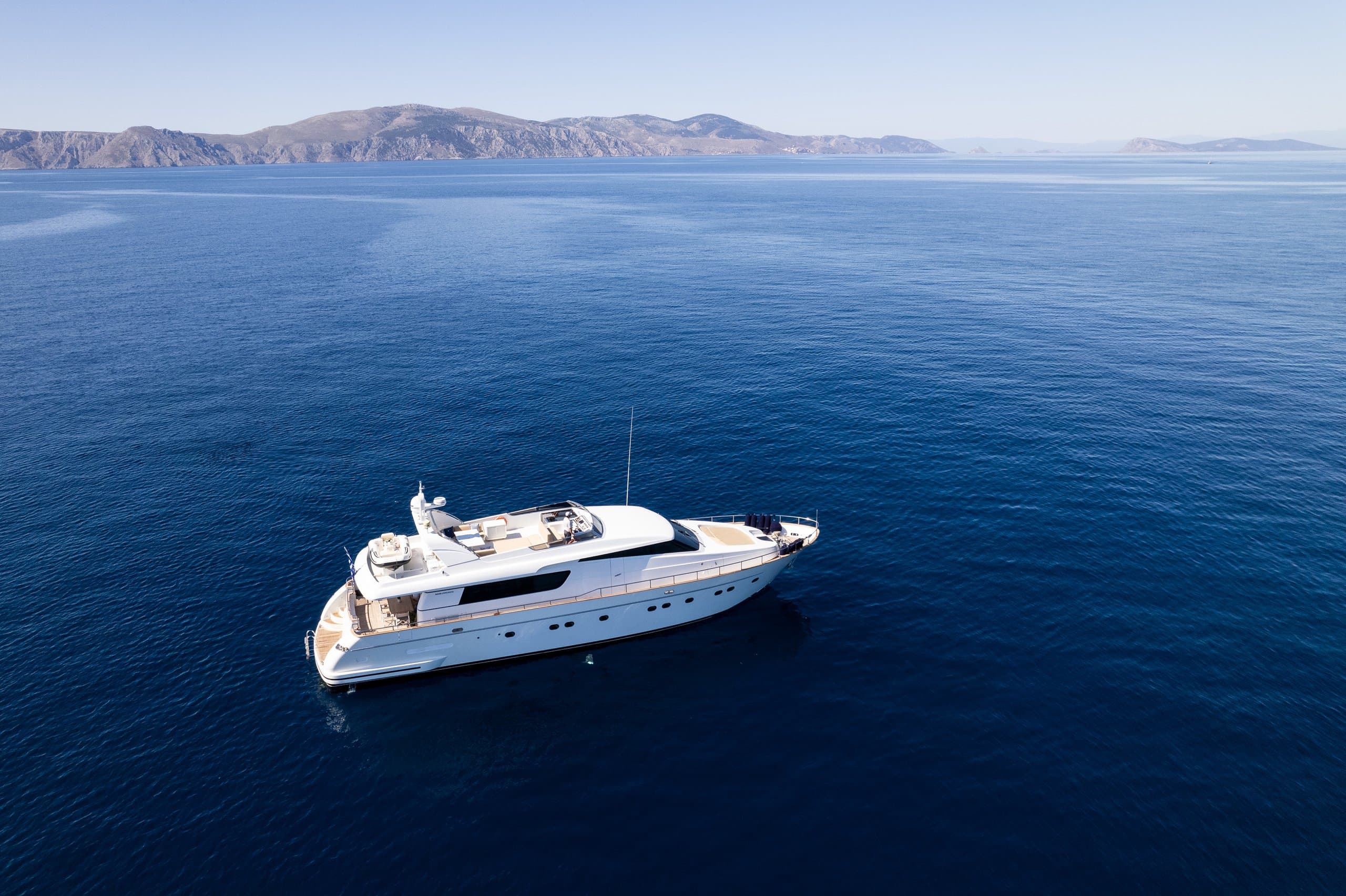 ALEGRIA - aerial profile of the motor yacht at anchor on deep blue open water | Drivas Yachts