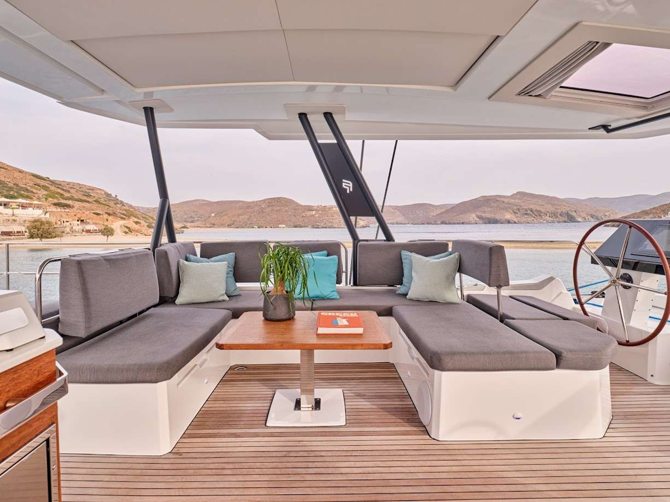 DOLLY - flybridge lounge seating with table and helm wheel | Drivas Yachts
