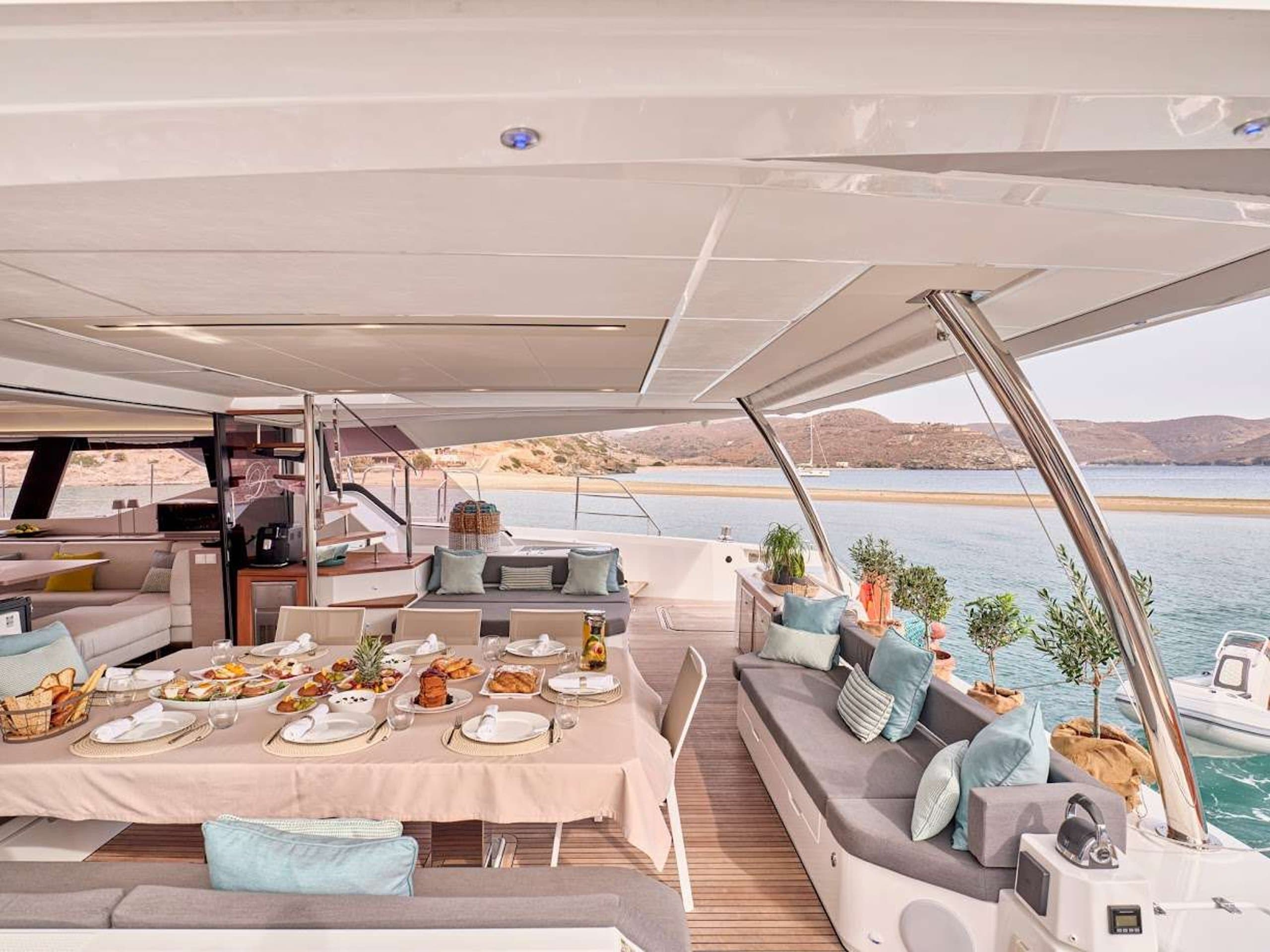 DOLLY - aft deck dining area with buffet spread and lounge seating | Drivas Yachts