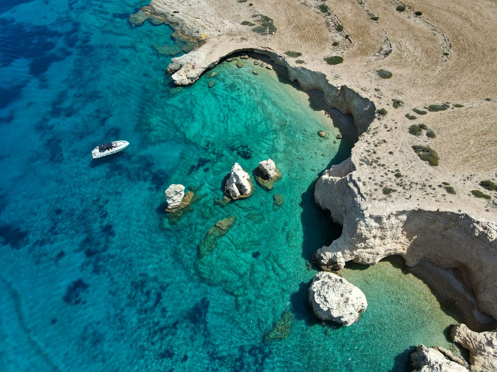 Aerial view of turquoise waters and yacht at Koufonisia