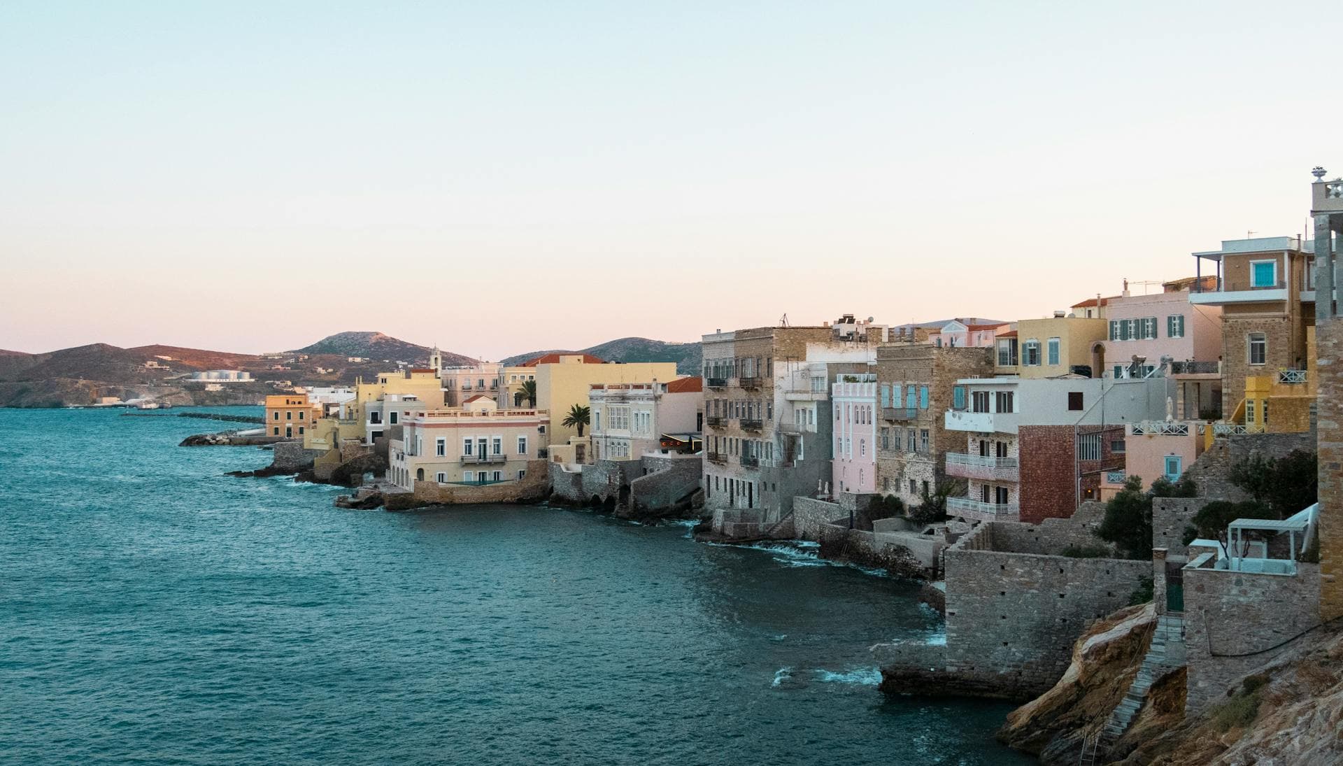 Syros Ermoupoli waterfront at dusk with pastel neoclassical buildings