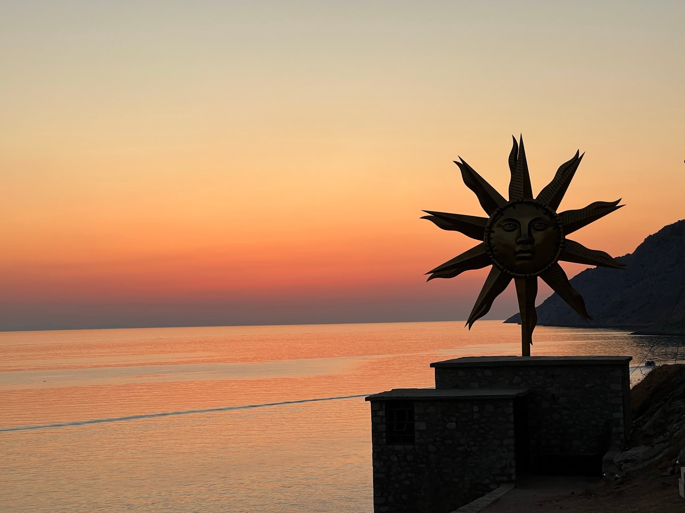 Sunset over the Saronic from Hydra, the sun sculpture in silhouette