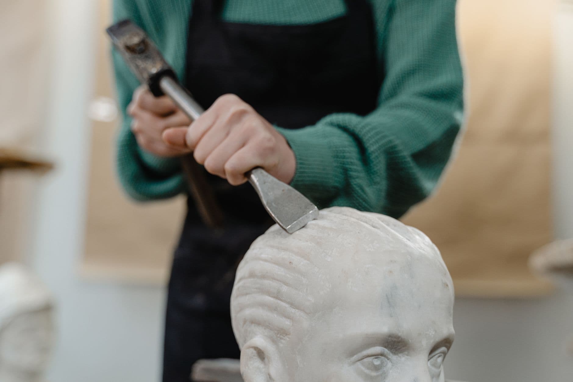 A sculptor working marble with chisel and hammer